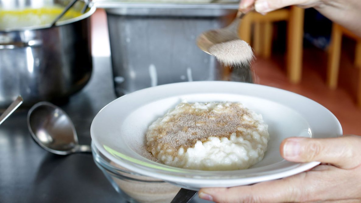 Eine Portion Milchreis wird in der Hortküche mit Zimt bestreut.