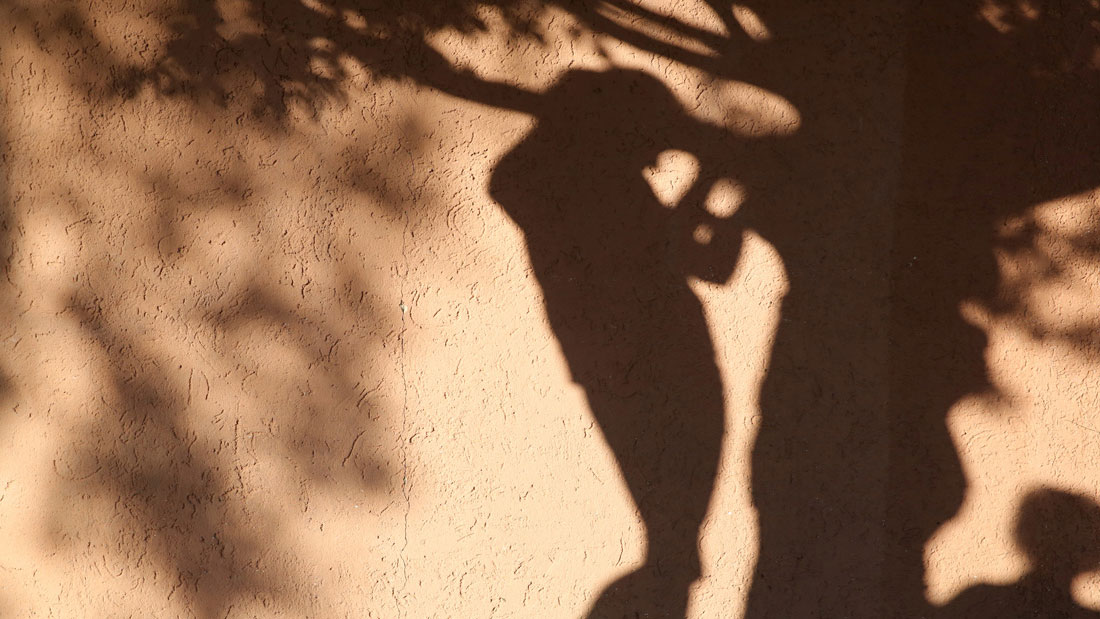 Schatten eines Erwachsenen und eines Kindes als Symbolbild zum Schutzkonzept.